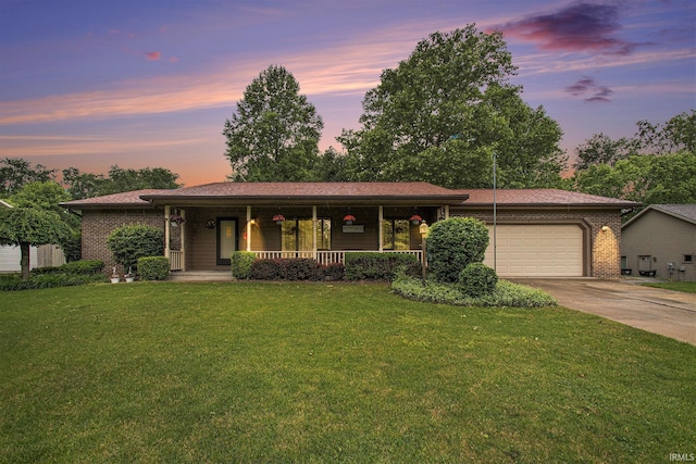 51301 Green Hill Dr, South Bend, IN 46628 - ranch-style house featuring covered porch, a garage, concrete driveway, and a front yard