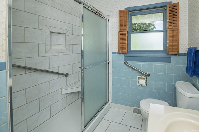 2330 N Fritz Dr, Bloomington, IN 47408 - bathroom featuring a shower stall, wallpapered walls, tile patterned floors, and tile walls