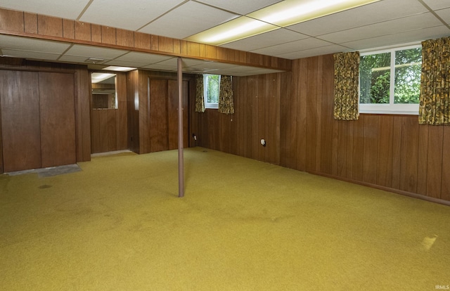 2330 N Fritz Dr, Bloomington, IN 47408 - basement with a paneled ceiling, wood walls, plenty of natural light, and carpet