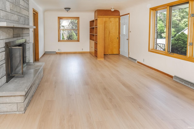 2330 N Fritz Dr, Bloomington, IN 47408 - unfurnished living room with plenty of natural light, a stone fireplace, and light wood finished floors