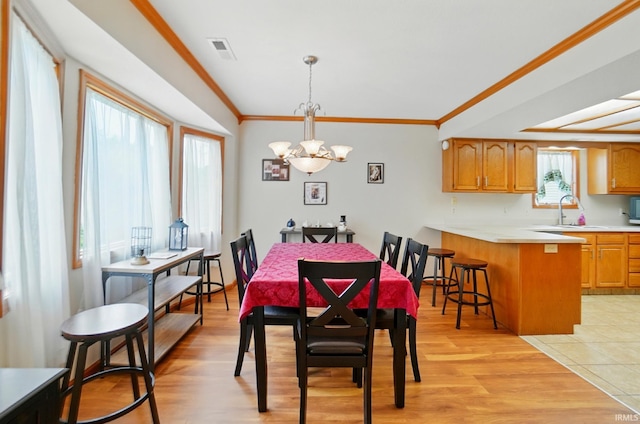 1322 Canal Ridge Dr, New Haven, IN 46774 - dining area with a chandelier, crown molding, and light wood-style floors