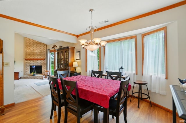 1322 Canal Ridge Dr, New Haven, IN 46774 - dining area featuring a chandelier, healthy amount of natural light, a fireplace, wood finished floors, and ornamental molding