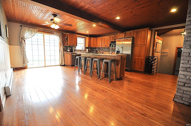 8077 E State Road 4th Rd, Walkerton, IN 46574 - kitchen featuring appliances with stainless steel finishes, brown cabinetry, a kitchen bar, ceiling fan, and a wooden ceiling with exposed beams