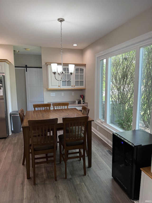 5844 Flagstone Dr, Evansville, IN 47711 - dining room with dark wood-type flooring, a barn door, and a chandelier