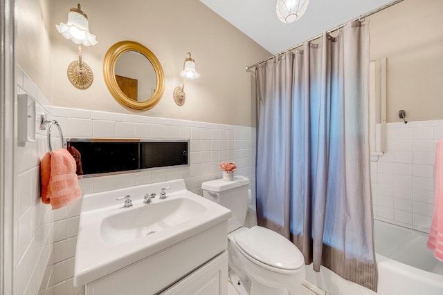 1402 Jackson Rd, South Bend, IN 46614 - full bathroom featuring tile walls, vanity, shower / bath combination with curtain, wainscoting, and vaulted ceiling