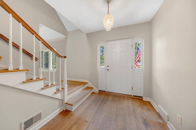 1402 Jackson Rd, South Bend, IN 46614 - foyer featuring healthy amount of natural light, wood finished floors, stairs, and a chandelier