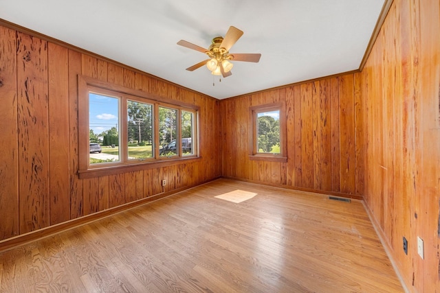 1402 Jackson Rd, South Bend, IN 46614 - spare room with light wood-type flooring, a ceiling fan, and wood walls