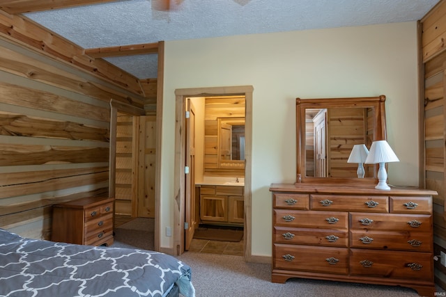 1275 N Sewell Rd, Bloomington, IN 47408 - carpeted bedroom featuring wooden walls, a textured ceiling, ensuite bath, and tile patterned flooring