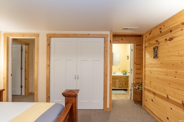 1275 N Sewell Rd, Bloomington, IN 47408 - bedroom featuring light carpet, wood walls, and ensuite bathroom