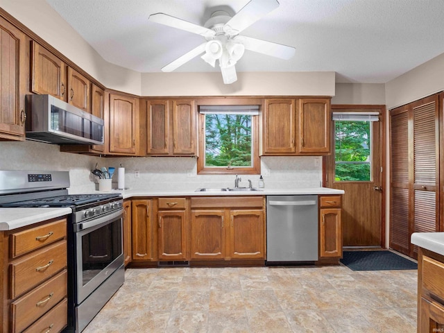 3723 Pebblewood Pl, Fort Wayne, IN 46804 - kitchen with stainless steel appliances, light countertops, brown cabinets, and a textured ceiling