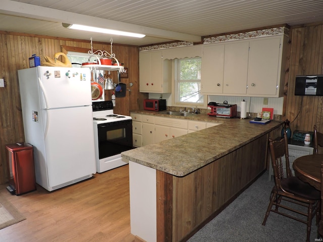 3643 S Bruner Rd, Warsaw, IN 46580 - kitchen featuring freestanding refrigerator, range with electric stovetop, wooden walls, a peninsula, and light wood finished floors
