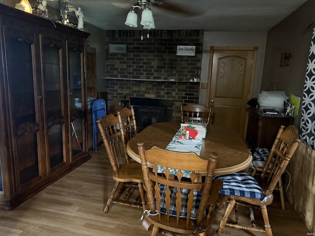 2286 N County Road 200 W, New Castle, IN 47362 - dining space featuring light wood-style flooring, ceiling fan, a fireplace, and a textured ceiling