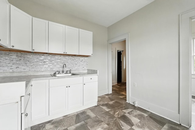 501 E Center St, Warsaw, IN 46580 - kitchen featuring tasteful backsplash, light countertops, white cabinetry, and stone finish floors