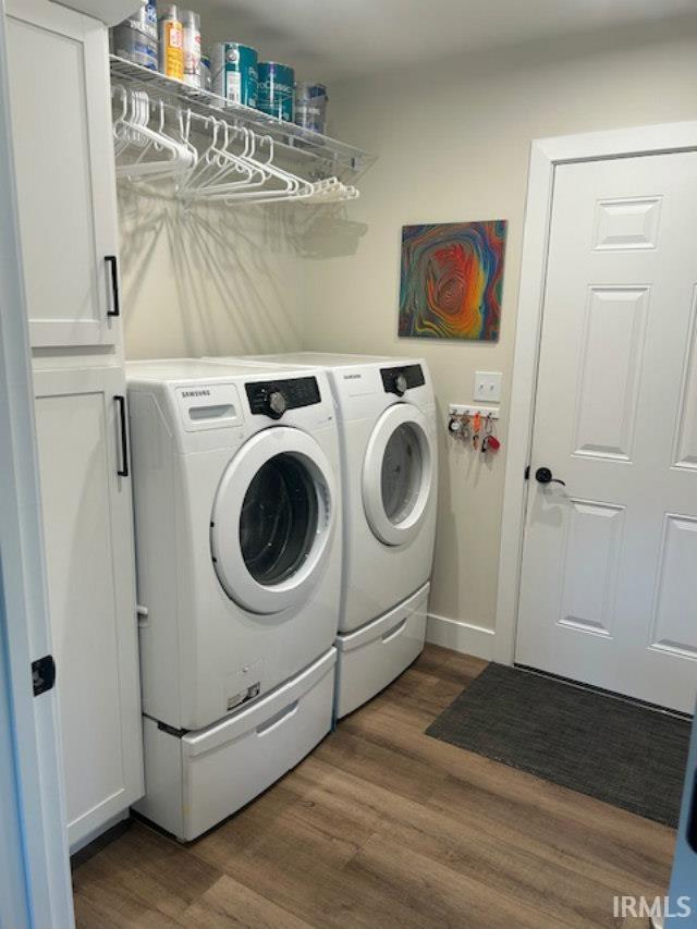 855 Reyling Dr, Jasper, IN 47546 - washroom featuring washing machine and dryer, cabinet space, and wood finished floors
