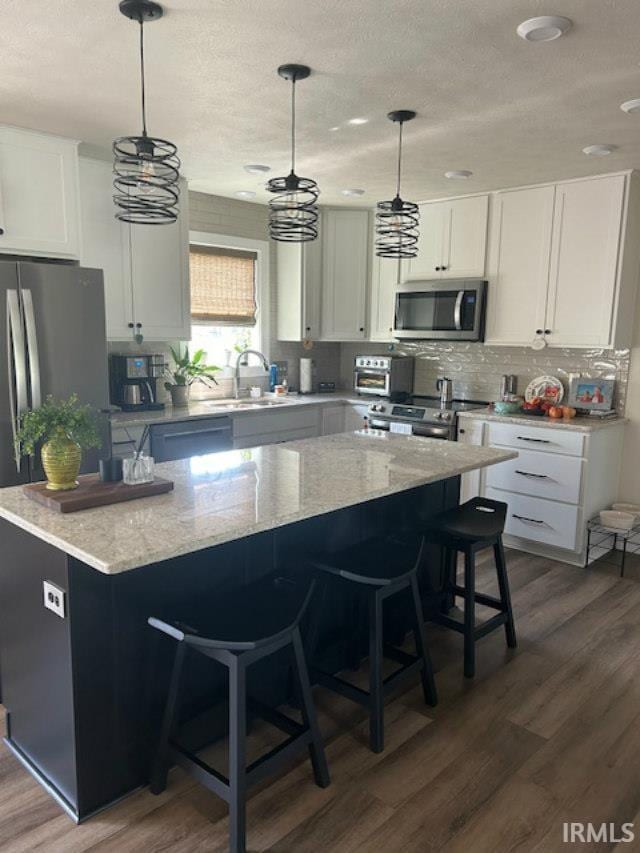 855 Reyling Dr, Jasper, IN 47546 - kitchen featuring stainless steel appliances, dark wood-type flooring, a textured ceiling, white cabinets, and light stone counters