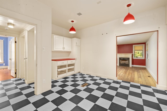2131 Kensington Blvd, Fort Wayne, IN 46805 - interior space with white cabinets, a fireplace, hanging light fixtures, and light flooring