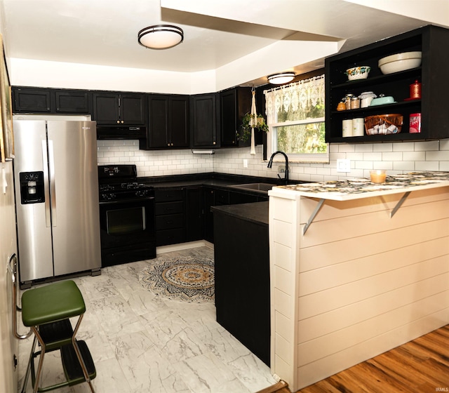 3945 W Walnut Leaf Dr, Bloomington, IN 47403 - kitchen with stainless steel refrigerator with ice dispenser, black gas range oven, ventilation hood, and dark cabinetry