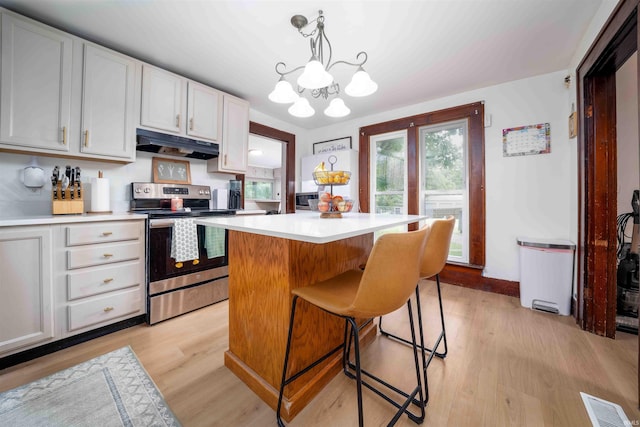 2220 N Huntington Rd, Marion, IN 46952 - kitchen featuring electric range, under cabinet range hood, light countertops, a kitchen island, and a chandelier