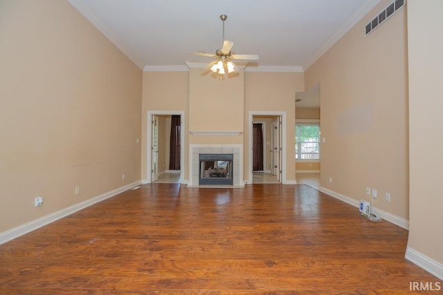2433 Wheaton Dr, Evansville, IN 47725 - unfurnished living room featuring a ceiling fan, ornamental molding, wood finished floors, and a tiled fireplace