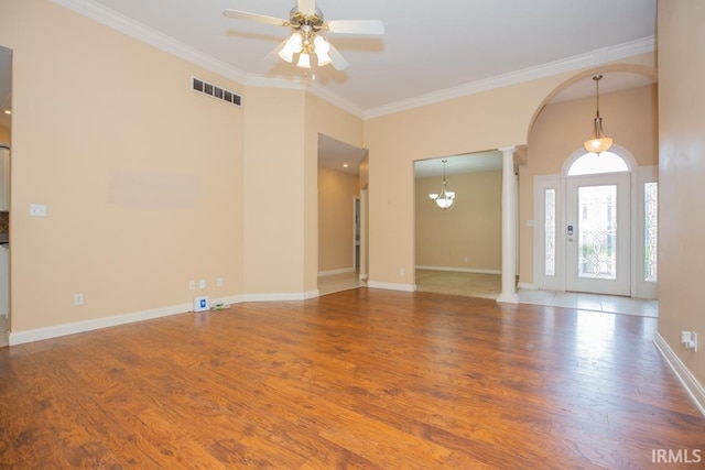 2433 Wheaton Dr, Evansville, IN 47725 - spare room with decorative columns, ceiling fan, wood finished floors, ornamental molding, and arched walkways