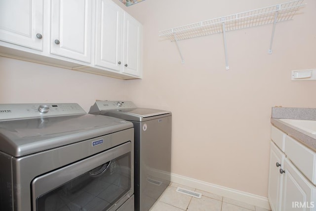2433 Wheaton Dr, Evansville, IN 47725 - laundry room with washing machine and clothes dryer, light tile patterned floors, and cabinet space