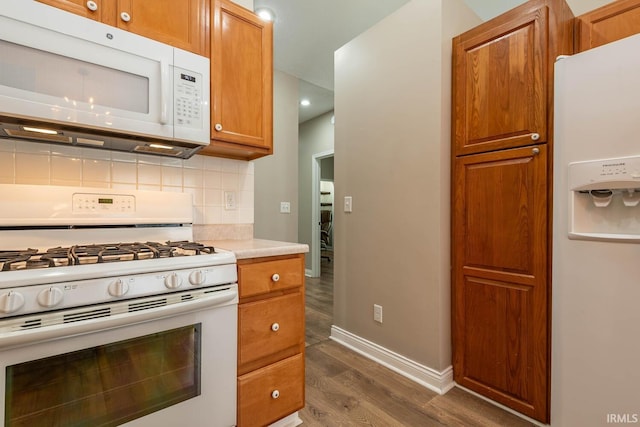 1423 W Westwind Ct, Bloomington, IN 47403 - kitchen with white appliances, dark wood-style floors, backsplash, brown cabinetry, and light countertops