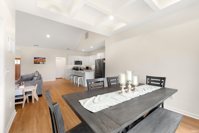 215 Mockingbird Ln, Warsaw, IN 46580 - dining space featuring light wood-style flooring, coffered ceiling, beam ceiling, recessed lighting, and high vaulted ceiling
