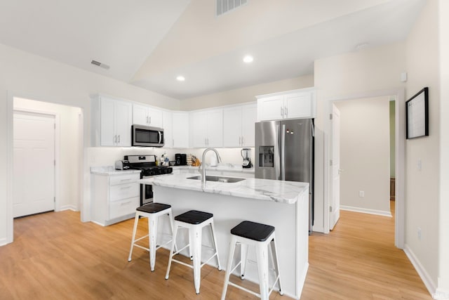 215 Mockingbird Ln, Warsaw, IN 46580 - kitchen with appliances with stainless steel finishes, white cabinets, a breakfast bar area, a center island with sink, and recessed lighting