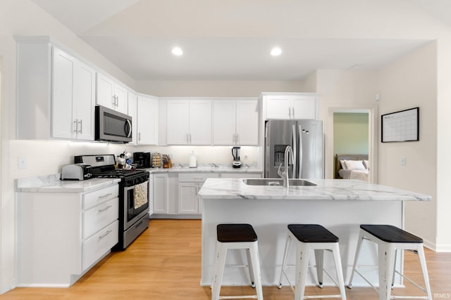 215 Mockingbird Ln, Warsaw, IN 46580 - kitchen featuring appliances with stainless steel finishes, a breakfast bar area, white cabinetry, light stone counters, and recessed lighting