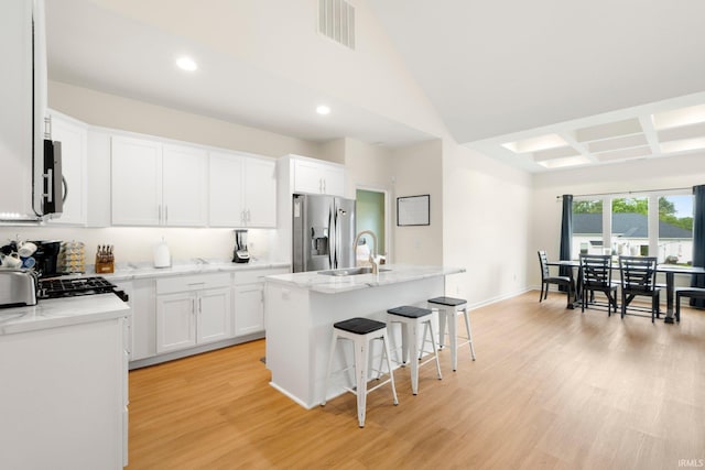 215 Mockingbird Ln, Warsaw, IN 46580 - kitchen with stainless steel appliances, recessed lighting, light wood-style flooring, a breakfast bar, and a center island with sink