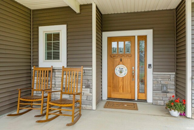 215 Mockingbird Ln, Warsaw, IN 46580 - doorway to property featuring stone siding and a porch