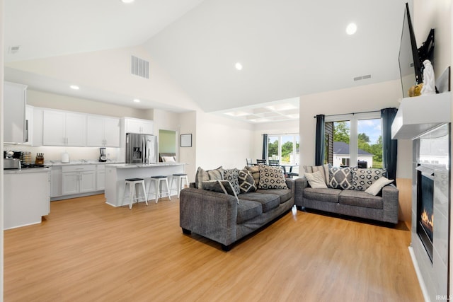 215 Mockingbird Ln, Warsaw, IN 46580 - living area featuring high vaulted ceiling, light wood-style floors, recessed lighting, and a glass covered fireplace