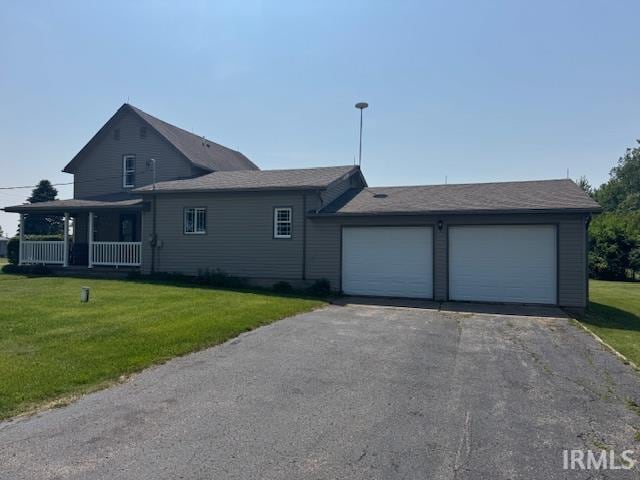 11748 W 450 N, Cromwell, IN 46732 - view of front facade with a front yard, an attached garage, asphalt driveway, and a porch