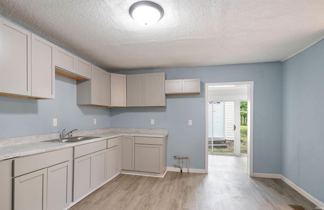 2305 N Armstrong St, Kokomo, IN 46901 - kitchen featuring light wood-type flooring, a textured ceiling, light countertops, and gray cabinetry