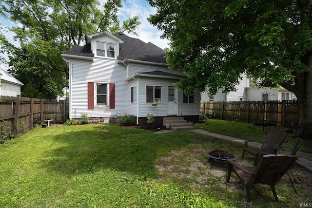 102 E Peterson St, Otterbein, IN 47970 - back of house with a fire pit, entry steps, a fenced backyard, and a shingled roof