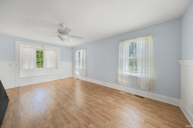7404 N State Road 13, North Webster, IN 46555 - spare room featuring a wainscoted wall, ceiling fan, and light wood-type flooring