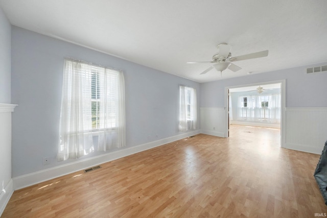 7404 N State Road 13, North Webster, IN 46555 - unfurnished room featuring a ceiling fan, light wood-style flooring, and a wainscoted wall