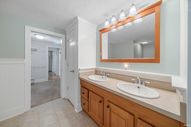 7404 N State Road 13, North Webster, IN 46555 - full bath featuring double vanity, tile patterned floors, a wainscoted wall, and a textured ceiling