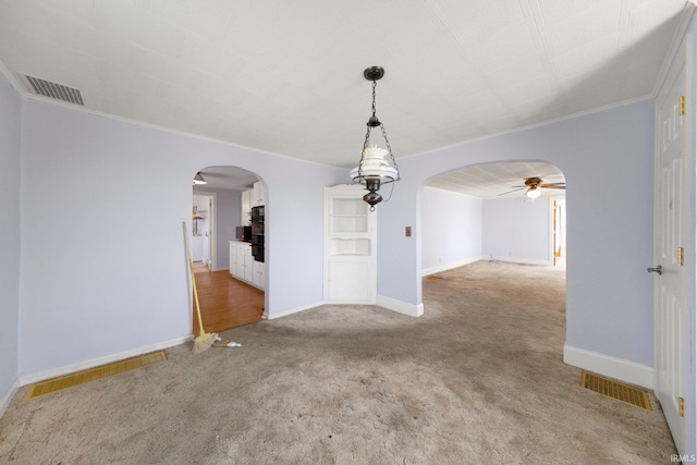7404 N State Road 13, North Webster, IN 46555 - unfurnished room featuring arched walkways, a ceiling fan, light carpet, and ornamental molding