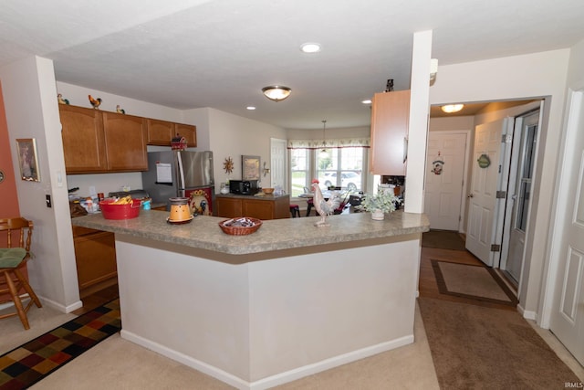 920 Cary Ct, South Bend, IN 46614 - kitchen featuring freestanding refrigerator, carpet floors, brown cabinets, recessed lighting, and a peninsula