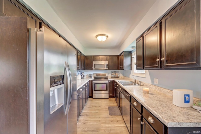 3121 S Yonkers St, Bloomington, IN 47403 - kitchen with stainless steel appliances, light wood finished floors, dark brown cabinetry, and light countertops