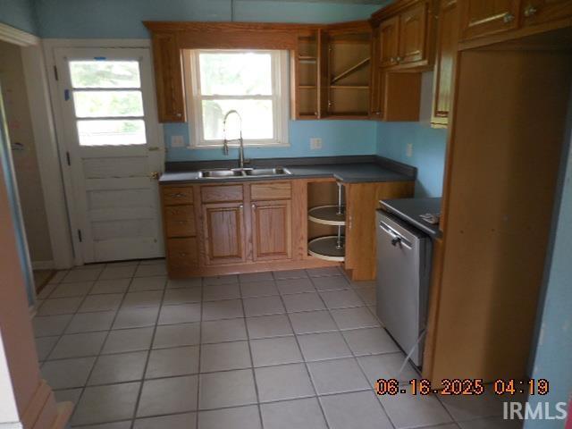 1608 Sunset Dr, Rochester, IN 46975 - kitchen featuring dark countertops, healthy amount of natural light, dishwasher, and light tile patterned flooring