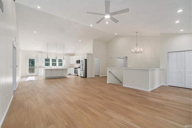 54207 Starner Ave, Elkhart, IN 46514 - unfurnished living room featuring high vaulted ceiling, light wood-type flooring, ceiling fan, recessed lighting, and a chandelier
