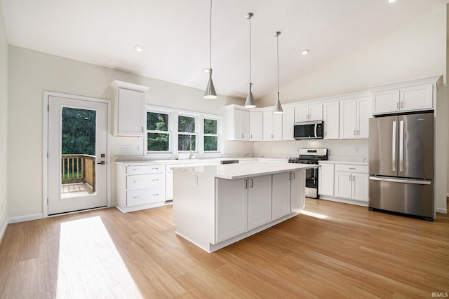 54207 Starner Ave, Elkhart, IN 46514 - kitchen with stainless steel appliances, light countertops, white cabinetry, light wood finished floors, and a kitchen island