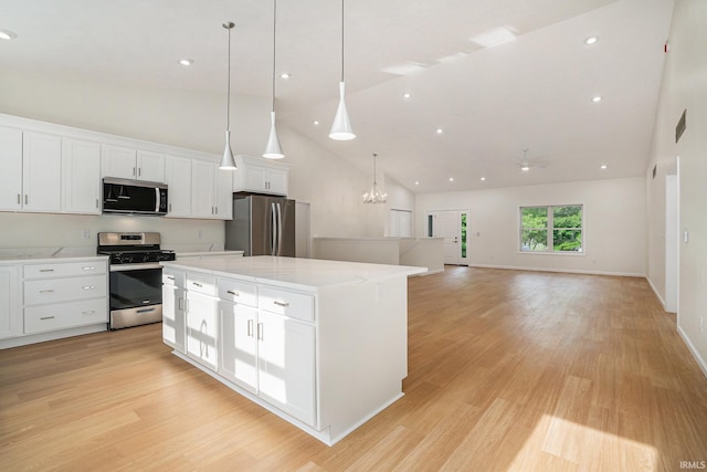 54207 Starner Ave, Elkhart, IN 46514 - kitchen with appliances with stainless steel finishes, high vaulted ceiling, white cabinets, a kitchen island, and light wood-type flooring