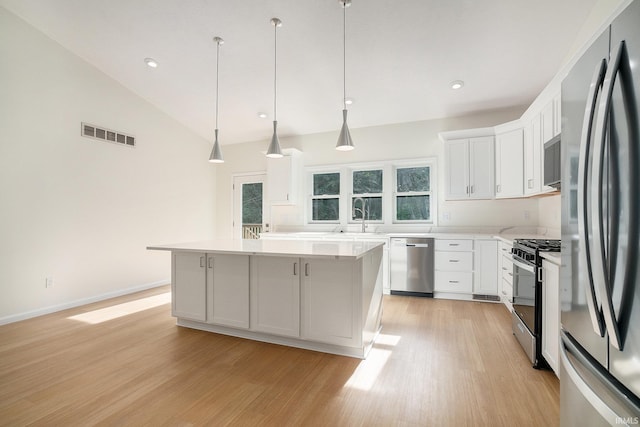 54207 Starner Ave, Elkhart, IN 46514 - kitchen featuring stainless steel appliances, light wood-style floors, light countertops, a kitchen island, and white cabinetry