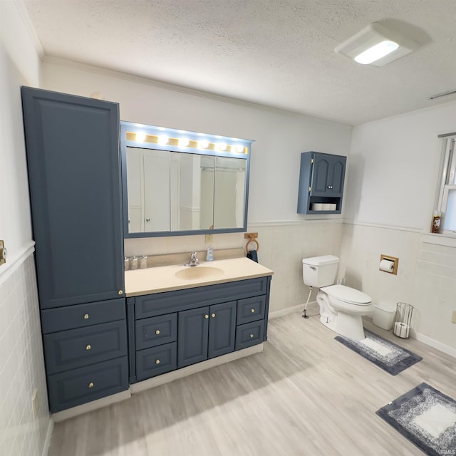 125 Ruby Rd, Attica, IN 47918 - bathroom featuring wood finished floors, a textured ceiling, vanity, a wainscoted wall, and crown molding