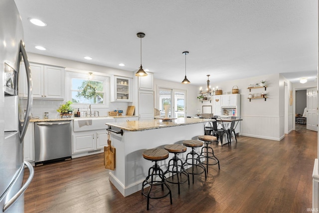6830 County Road 40, Butler, IN 46721 - kitchen featuring stainless steel appliances, a center island, a breakfast bar area, white cabinets, and a wainscoted wall