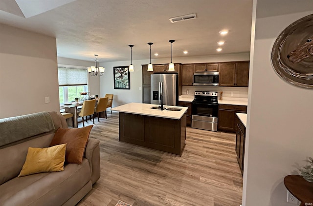 9 Beacon Way, Washington, IN 47501 - kitchen featuring appliances with stainless steel finishes, open floor plan, dark brown cabinets, a chandelier, and light countertops