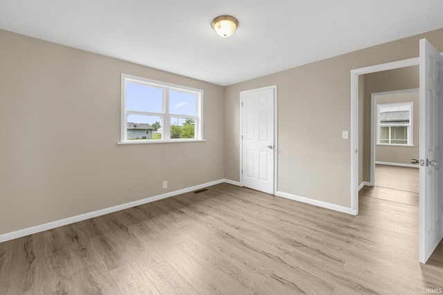 307 W Flora St, Washington, IN 47501 - unfurnished bedroom featuring multiple windows and light wood-style floors